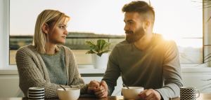 Man holding woman's hand at the breakfast table