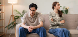 Angry married couple sitting with their backs to each other