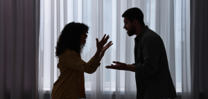 Husband and wife arguing in front of a closed curtain window and endangering their marriage with poor communication