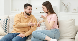 Couple sitting on a couch arguing