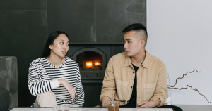 Woman speaking to a man defensively over cups of tea